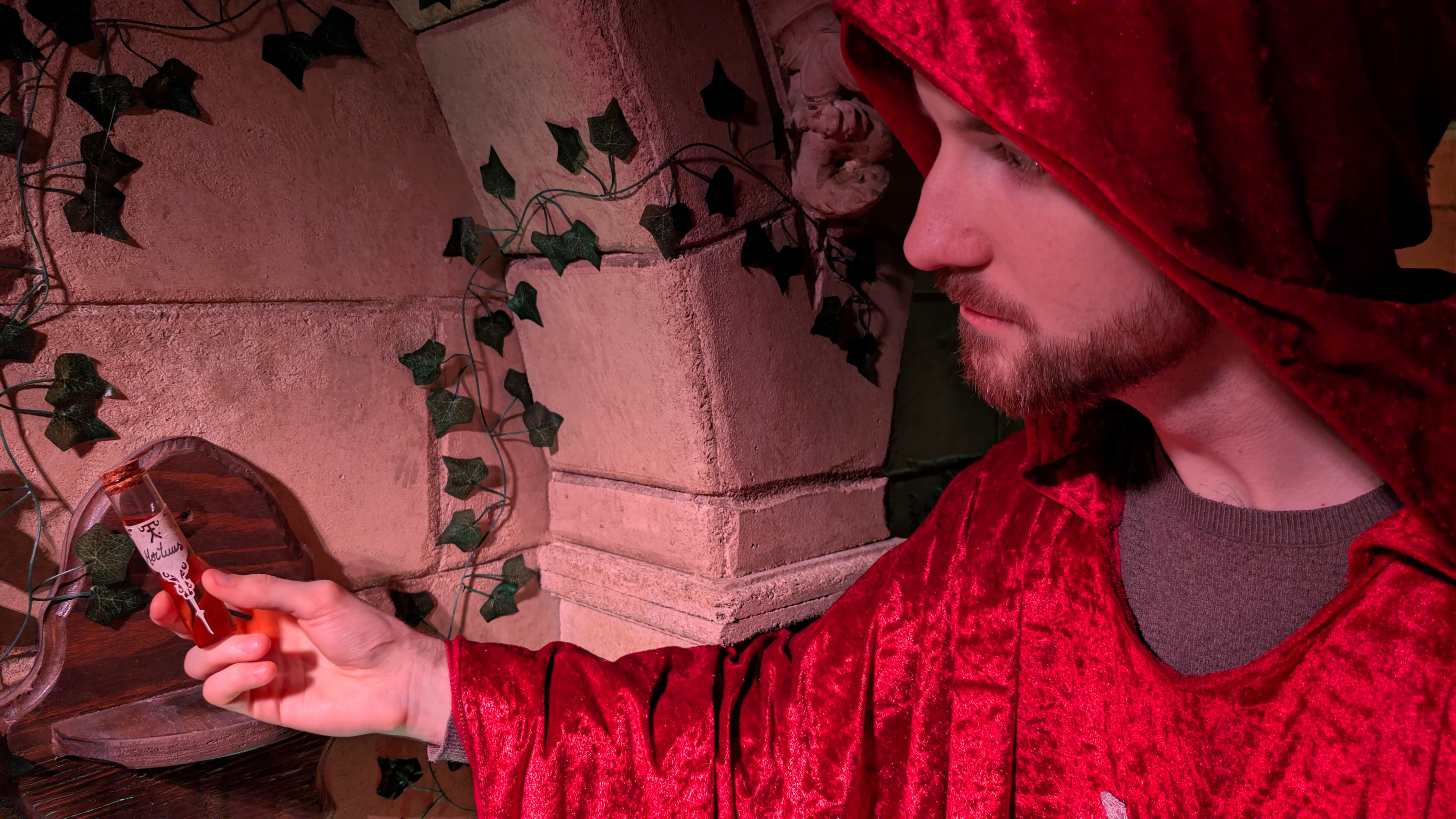 Wolf Gang - man wearing a red cloak and holding a flask